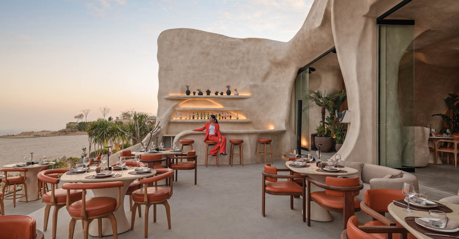 a restaurant with a view of the ocean and cavelike structure